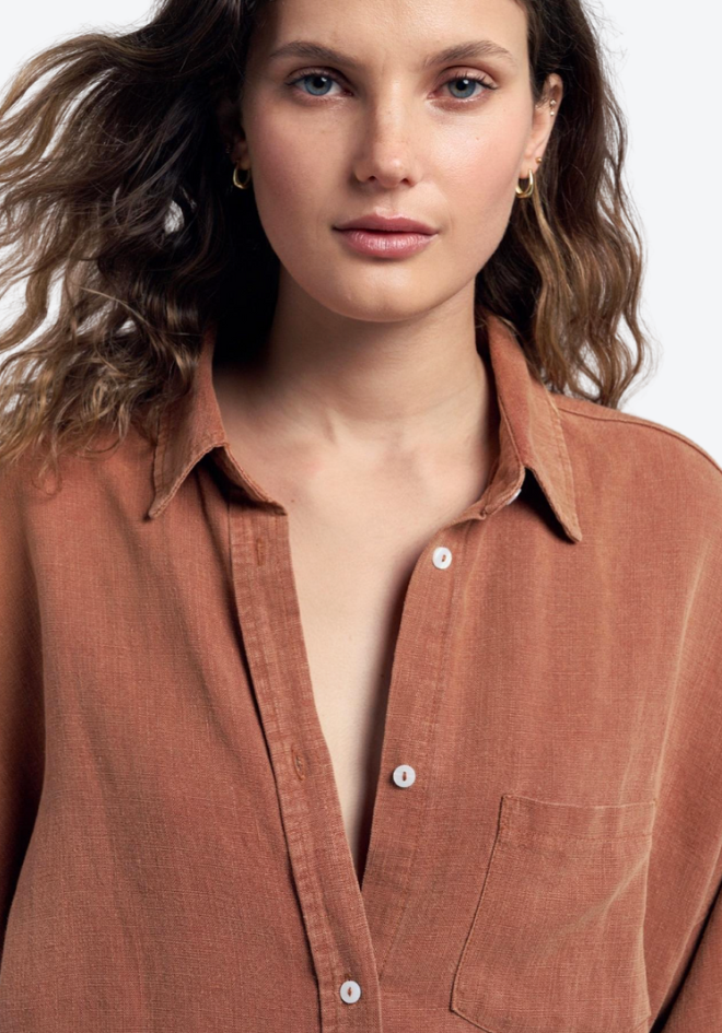 Woman wearing a brown shirt against a plain background