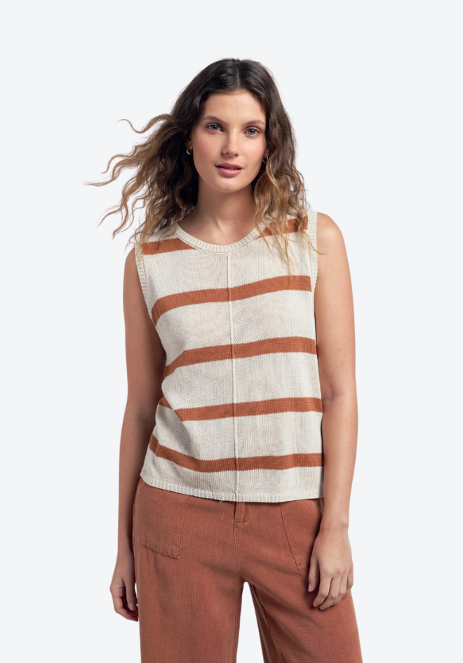 Woman wearing a sleeveless striped top and brown pants on a white background