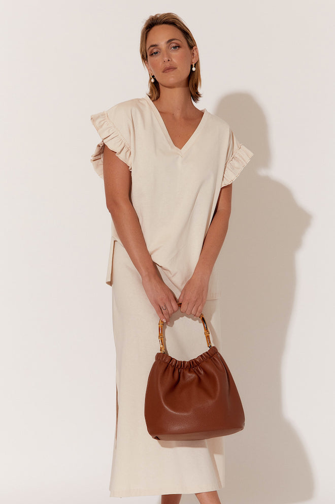 A brown textured handbag with a cane handle.