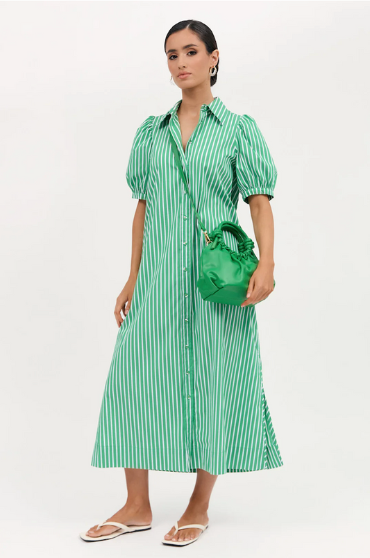 Woman wearing a green and white striped dress holding a matching handbag against a white background