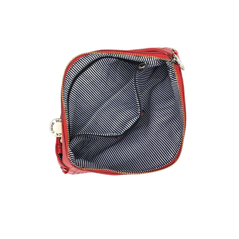 A red Nina crossbody clutch with a perforated front and a solid red back, displayed on a white background.
