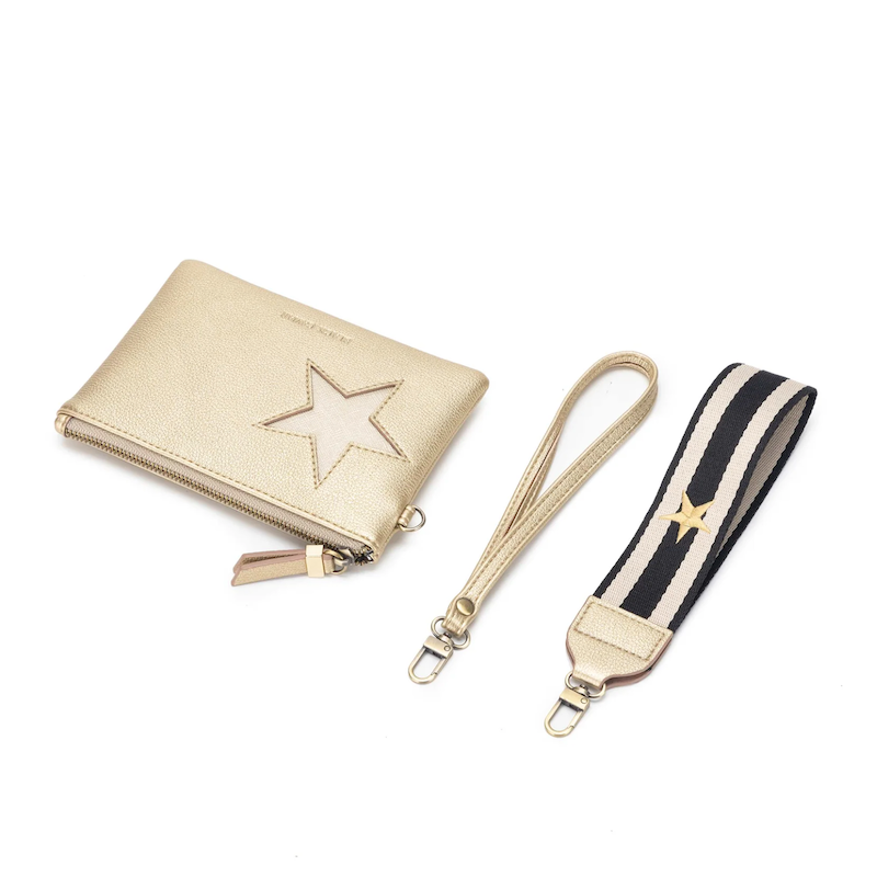 A gold-colored Stellina pouch with a metallic star detail on the front, gold hardware, and a black and white cotton wristlet strap.