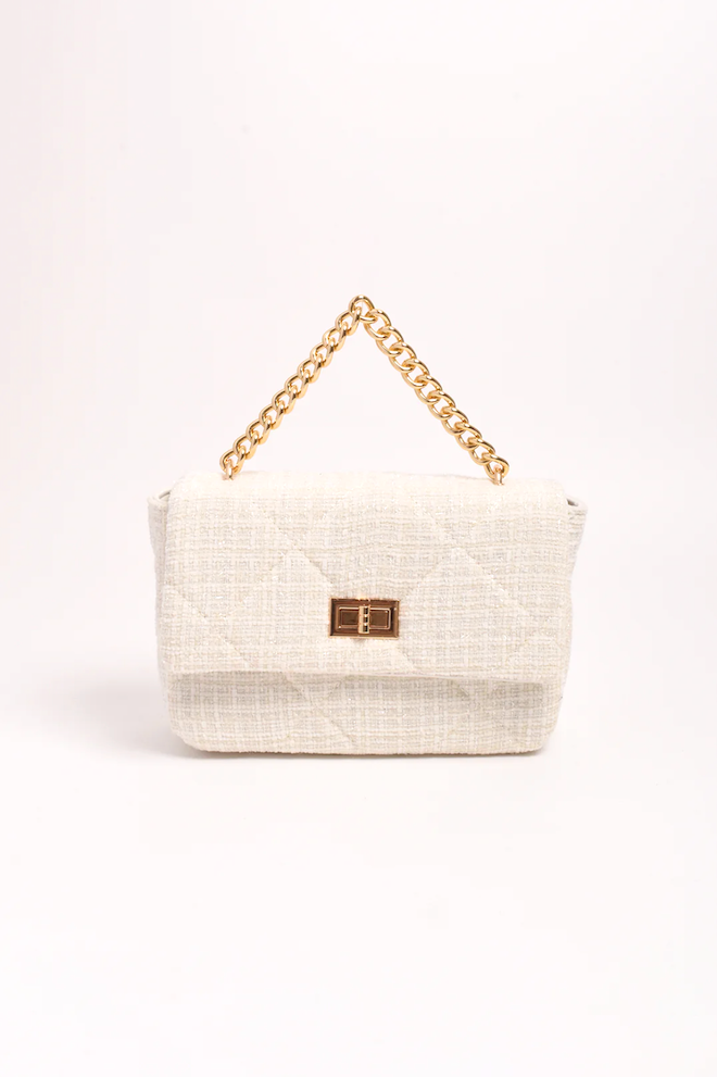 White handbag with gold chain handle on a white background