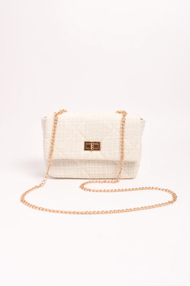 White handbag with gold chain strap on a white background