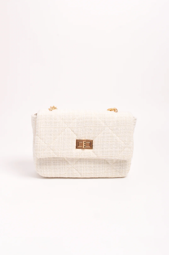 Beige woven basket with a gold clasp on a white background