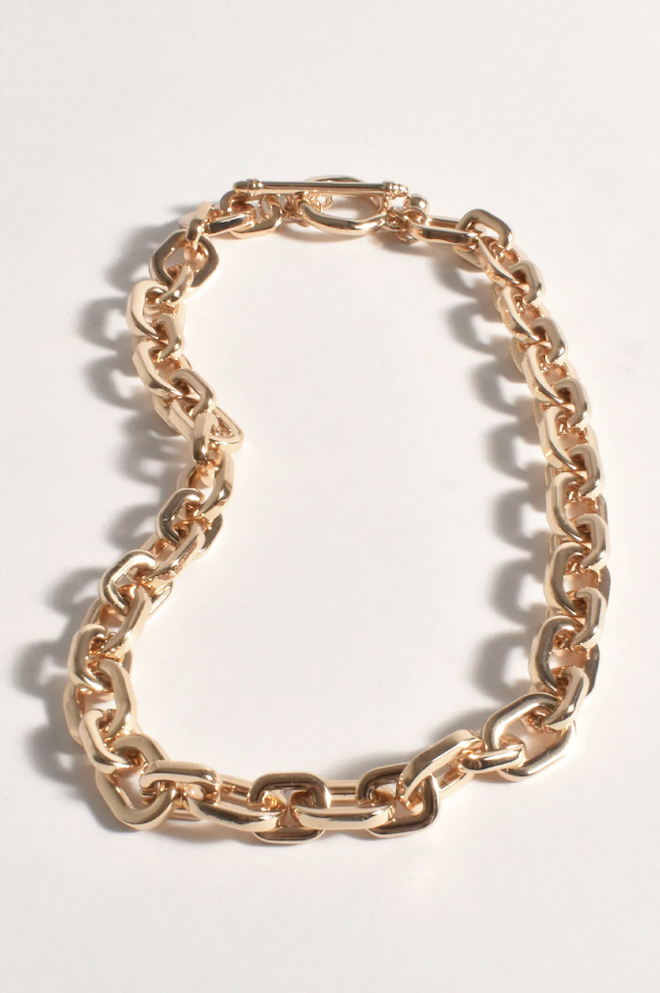 Gold chain bracelet on a light gray background
