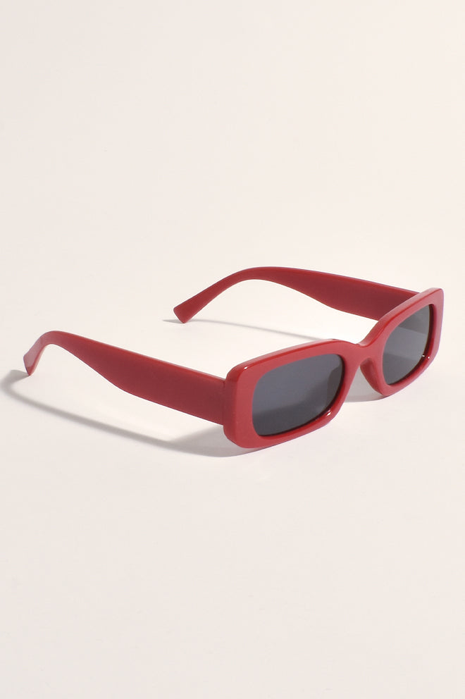 A pair of red sunglasses with a plastic frame and metal temples.