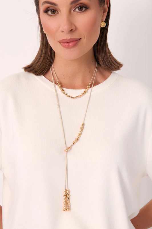 Woman wearing a gold necklace on a white background