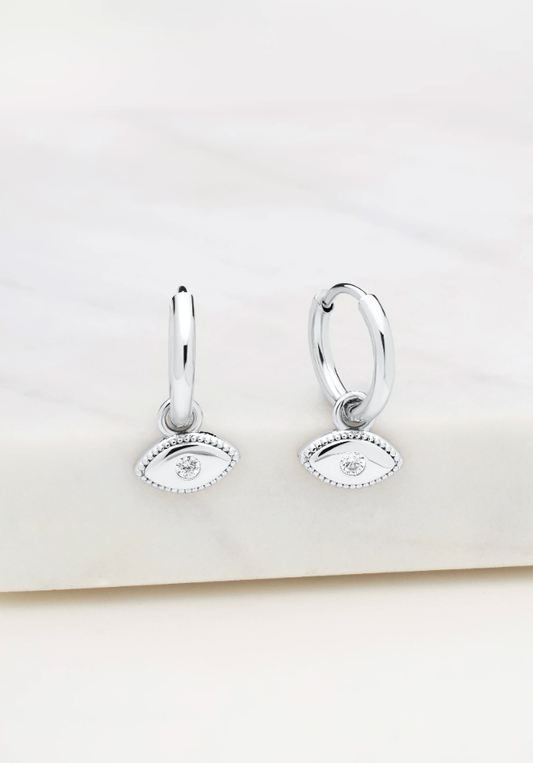 Silver hoop earrings with eye designs on a white background