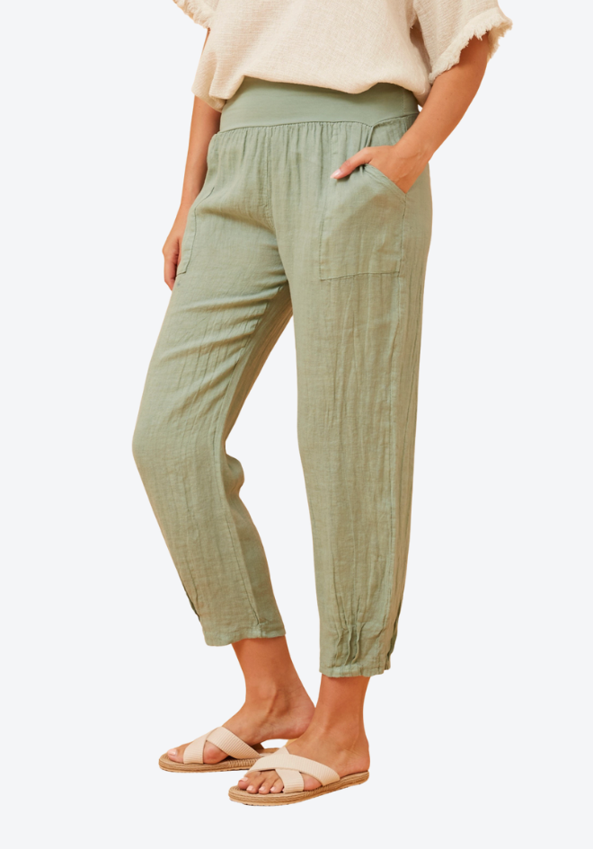 Person wearing light green pants on a white background