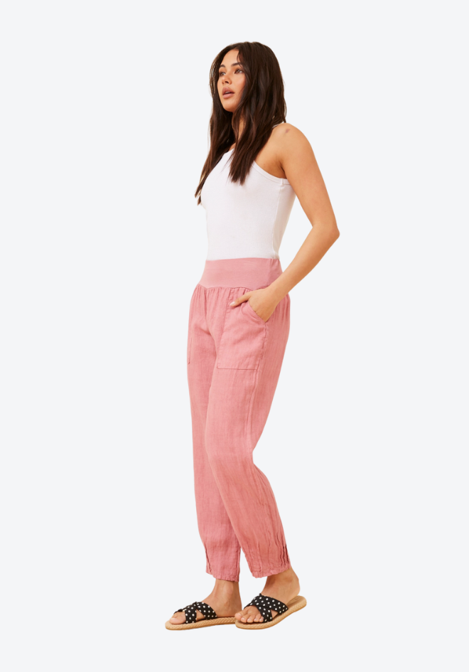 Woman wearing a white top and pink pants on a white background