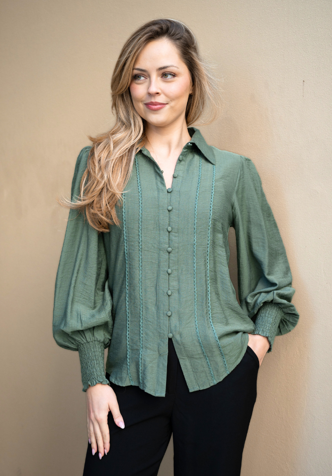 Woman wearing a green blouse against a beige background