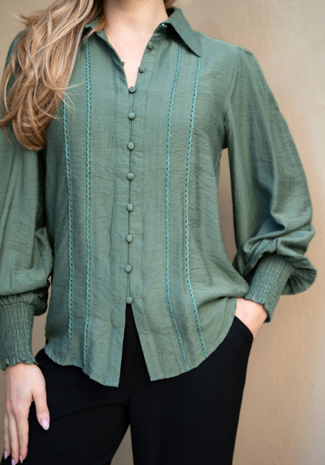 Green button-up shirt worn by a person against a beige background