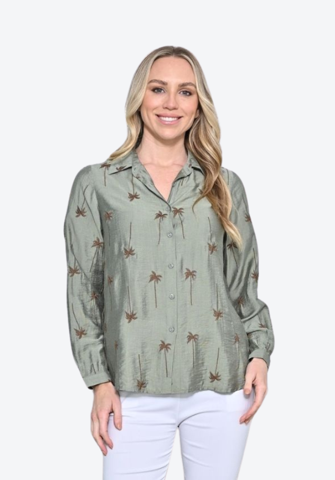 Woman wearing a green patterned shirt and white pants on a white background
