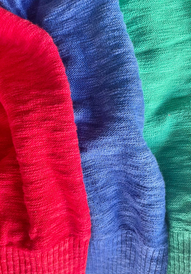 Close-up of red, blue, and green knitted fabrics.