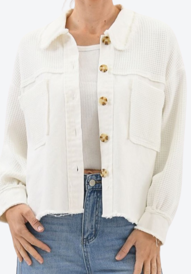 White denim jacket with gold buttons worn by a person on a white background