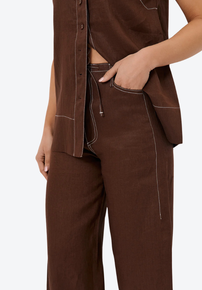 Brown shirt and pants worn by a person on a white background