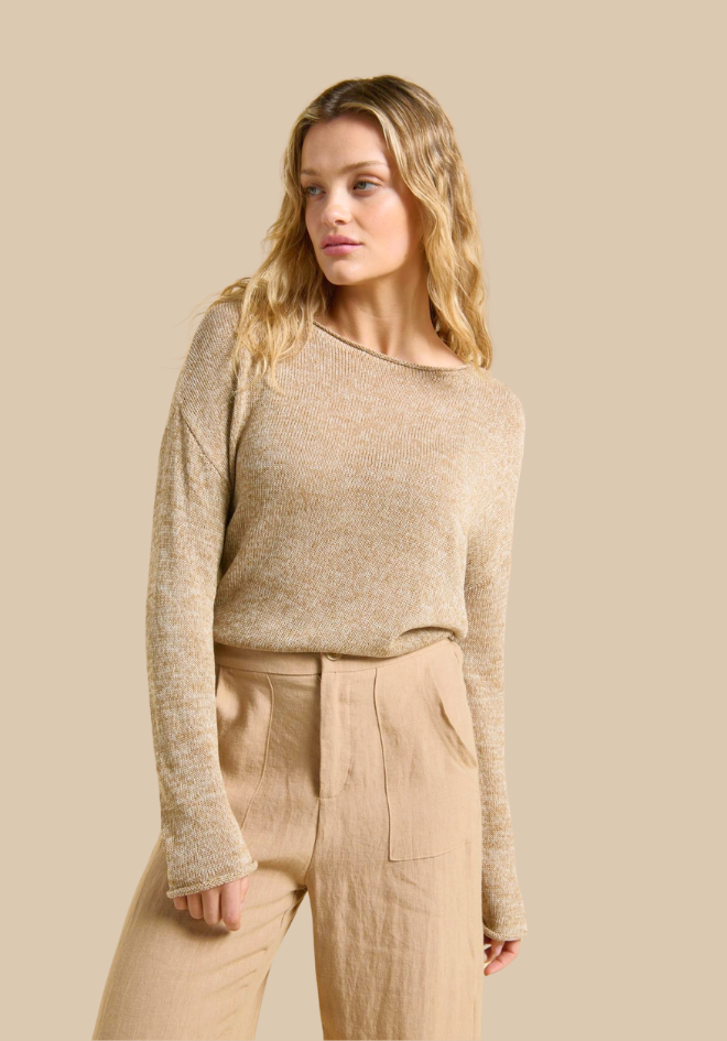 Woman wearing a beige sweater and pants against a beige background
