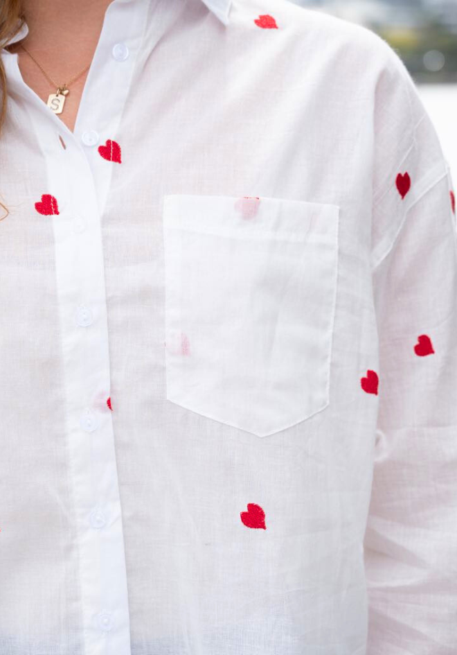 White shirt with red heart patterns on a blurred background