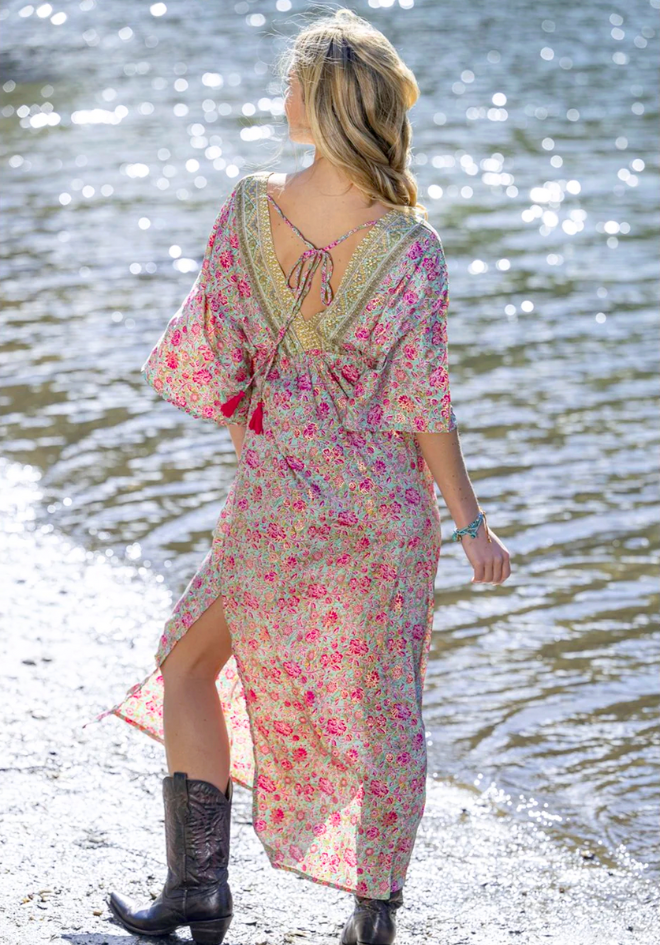 Woman in a floral dress standing by a body of water