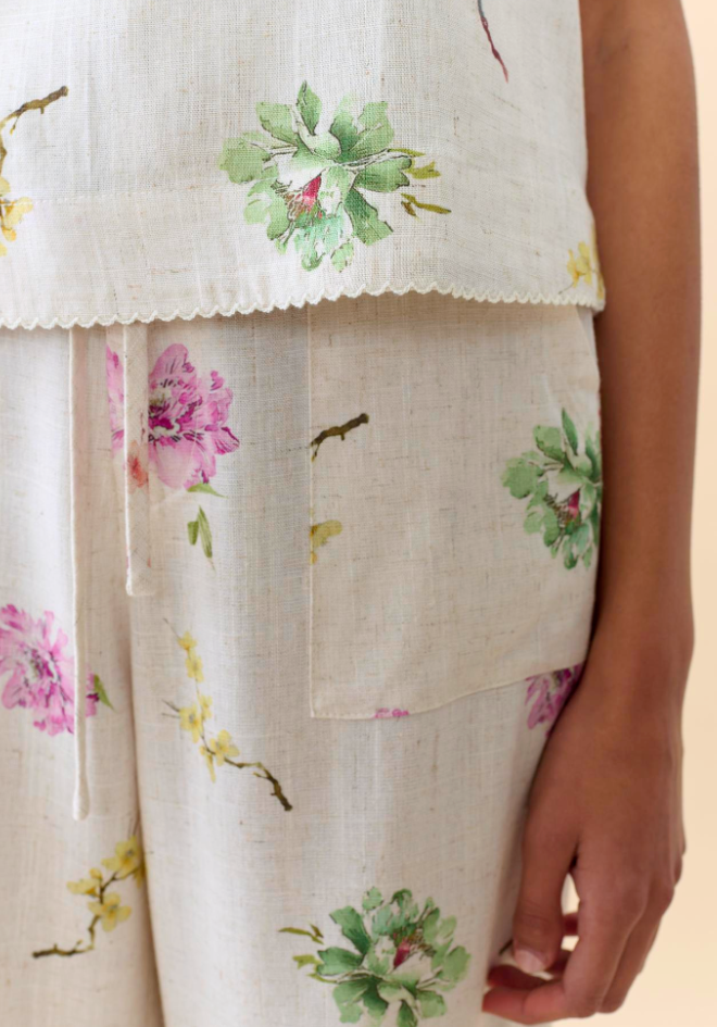 Floral embroidered top and pants on a person against a neutral background