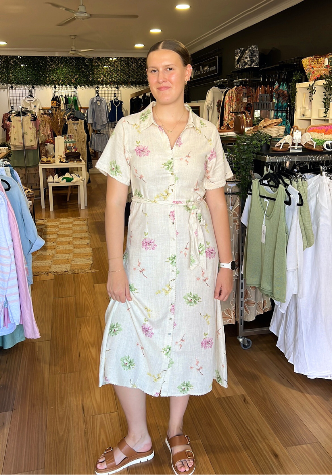 Woman in a floral dress standing in a clothing store