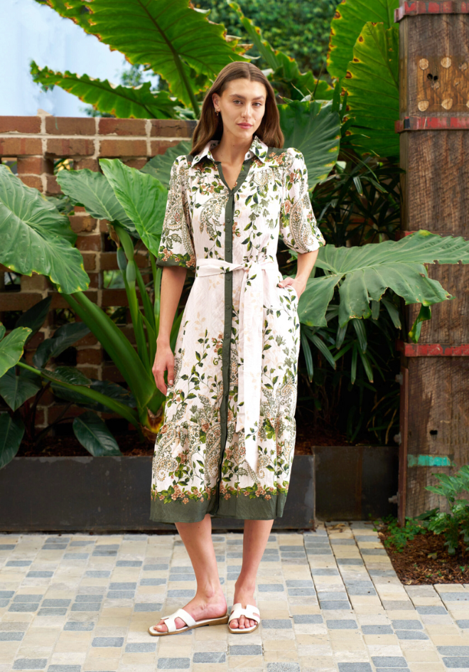 Woman wearing a floral dress standing in a garden setting