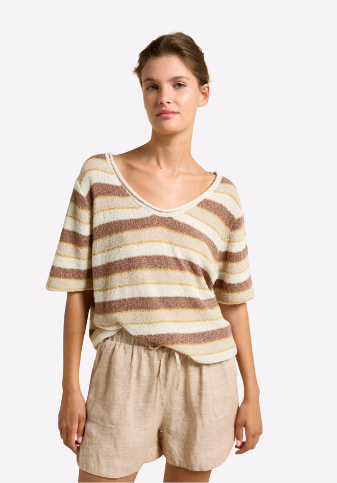 Woman wearing a striped shirt and beige shorts on a white background