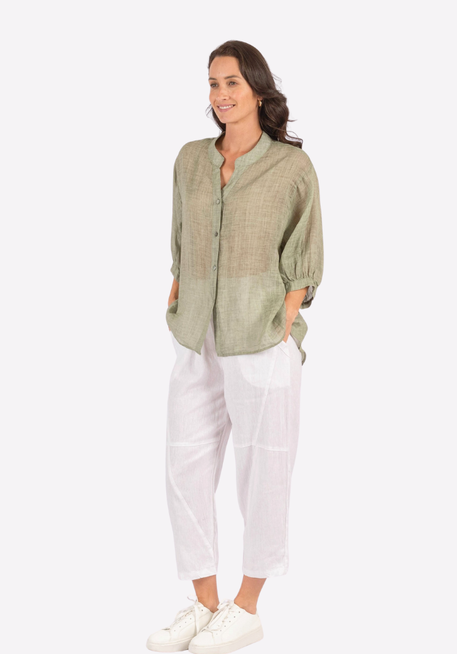 Woman wearing a green shirt and white pants on a white background