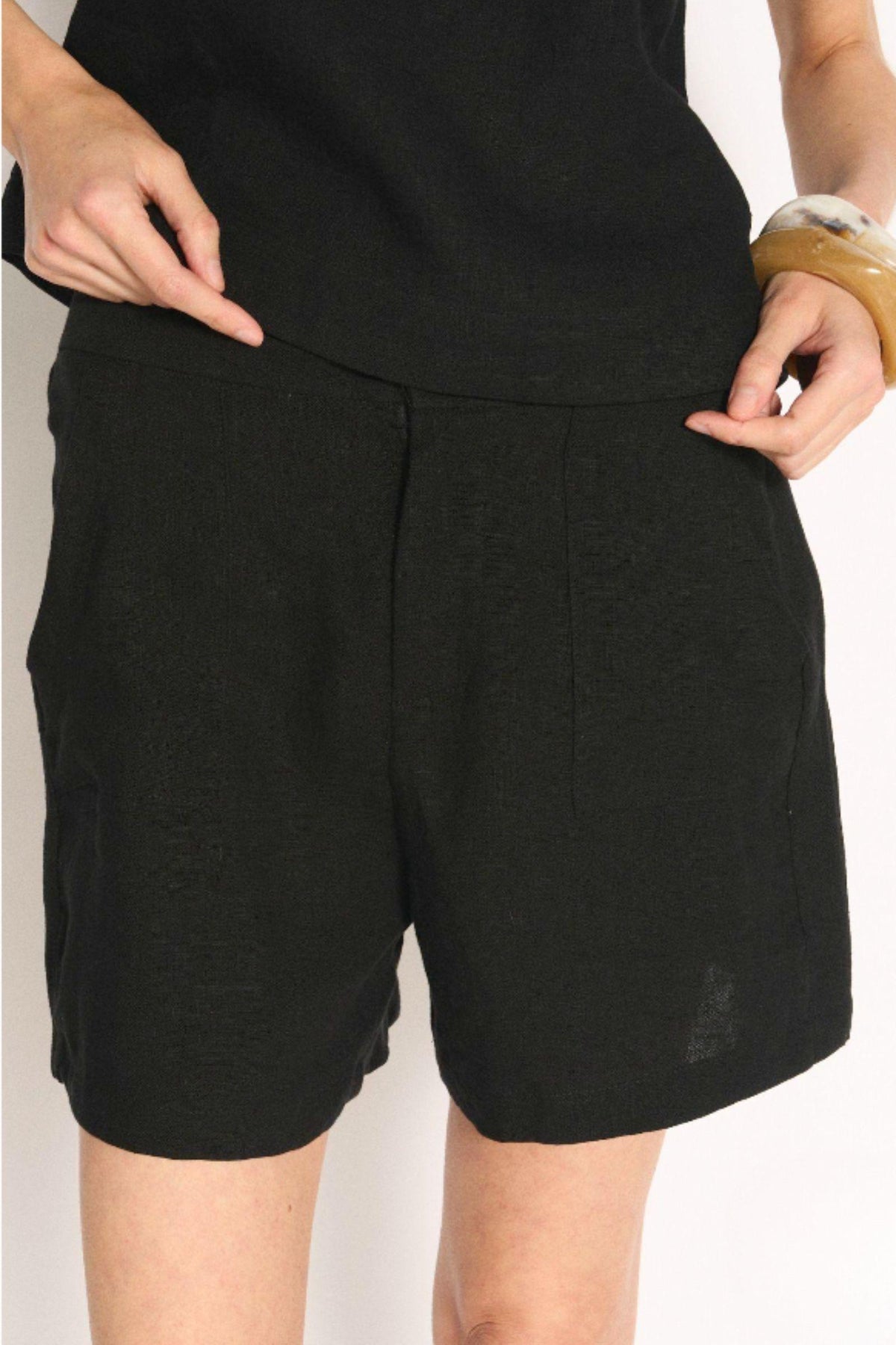Little Lies Jude Shorts in Black close-up of the front zip-to-button closure and linen texture