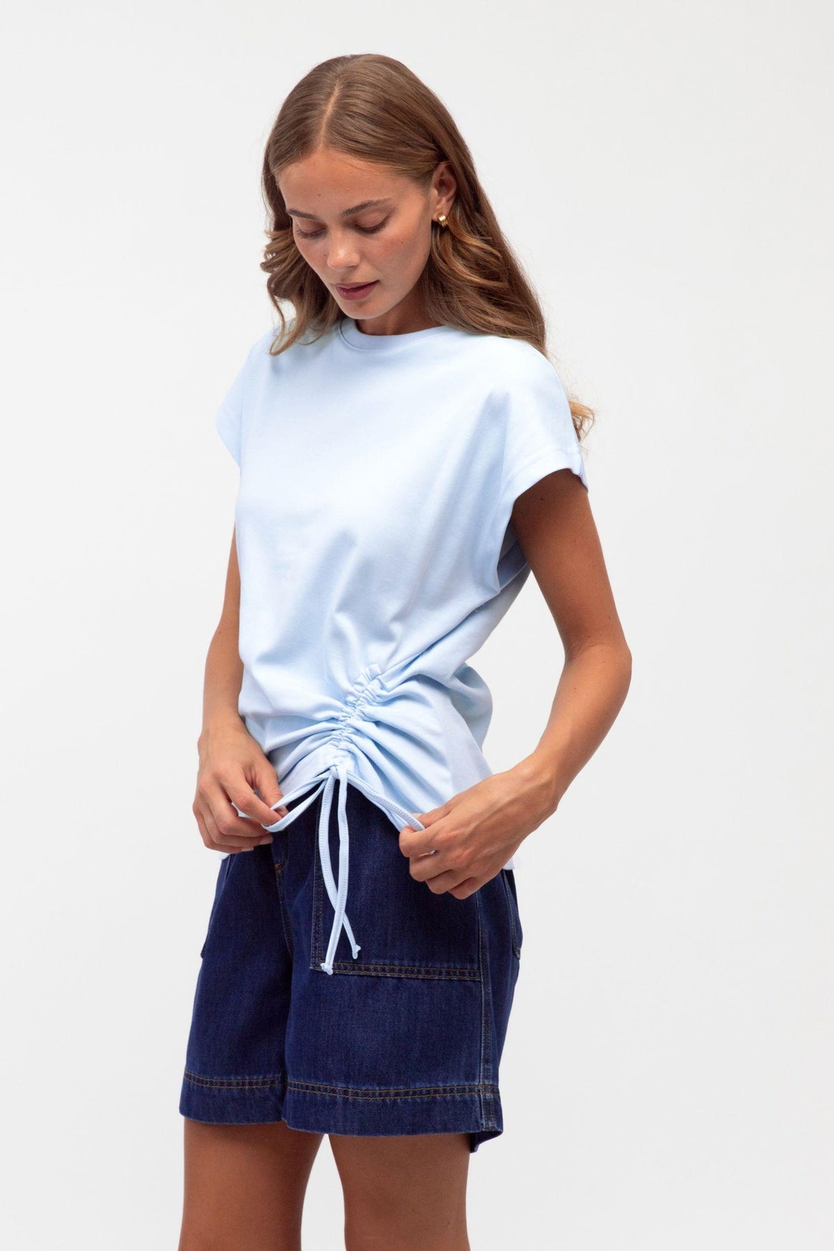Label of Love Mandy Drawstring Tee — angled view of the baby blue crew-neck tee and side drawstring, styled with navy shorts, available in Australia at Kat and Ko Clothing