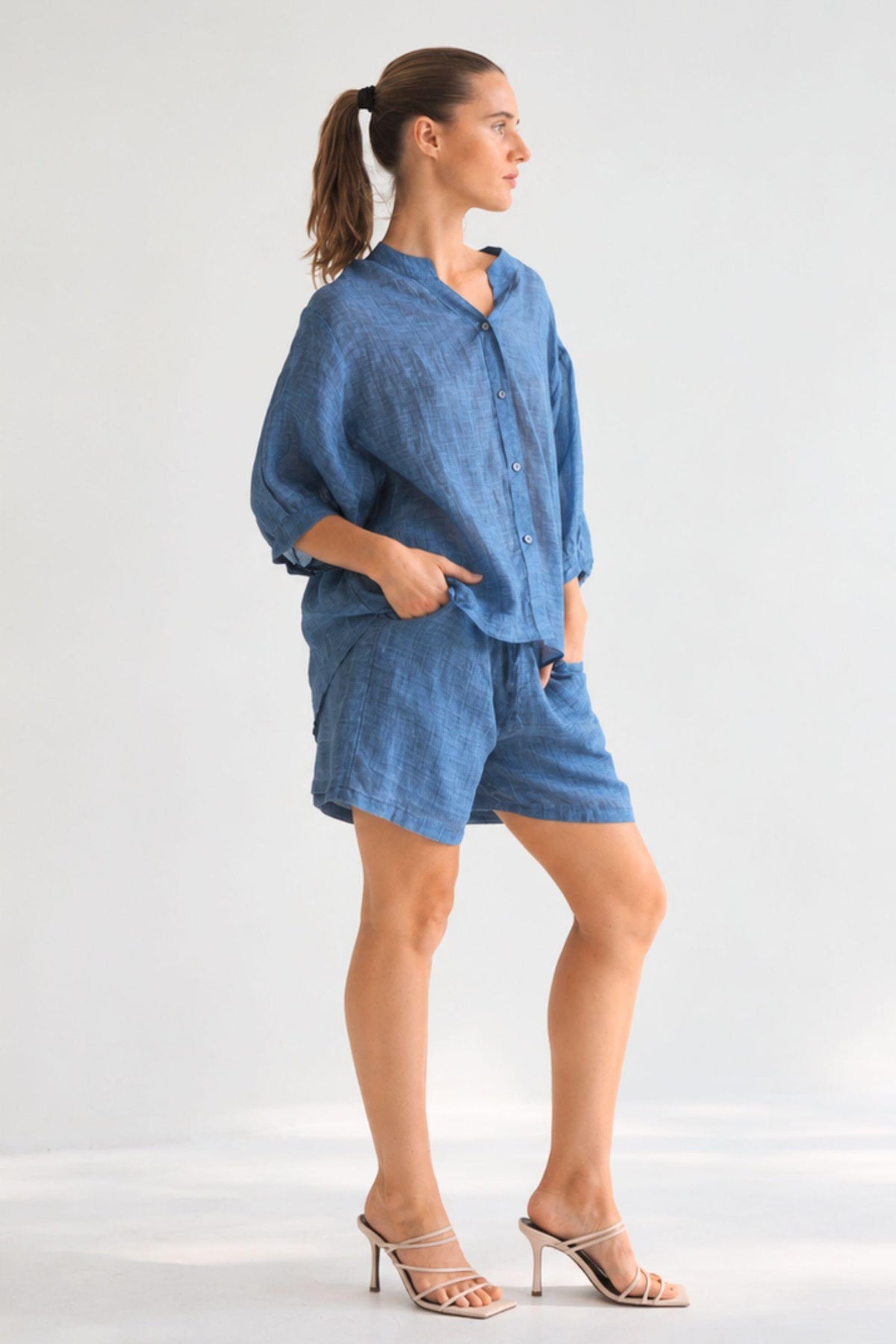 Worthier Aurora Linen Top and Eden Linen Shorts in Denim Blue, side view with hand in the shorts pocket