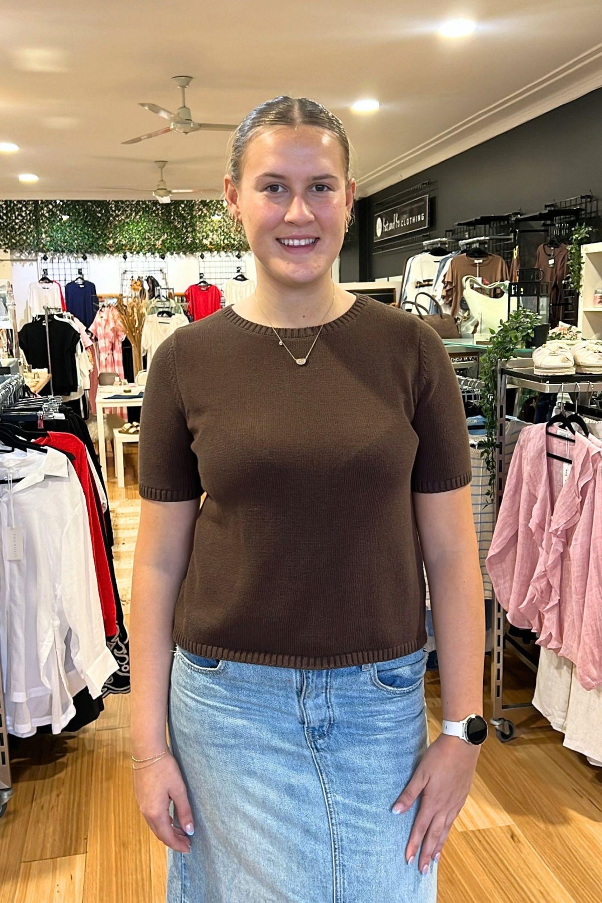 Rowie Knitted Tee by Little Lies — front view of a chocolate brown short-sleeve knitted tee with ribbed details, styled with light blue jeans in a boutique, available in Australia at Kat and Ko Clothing.