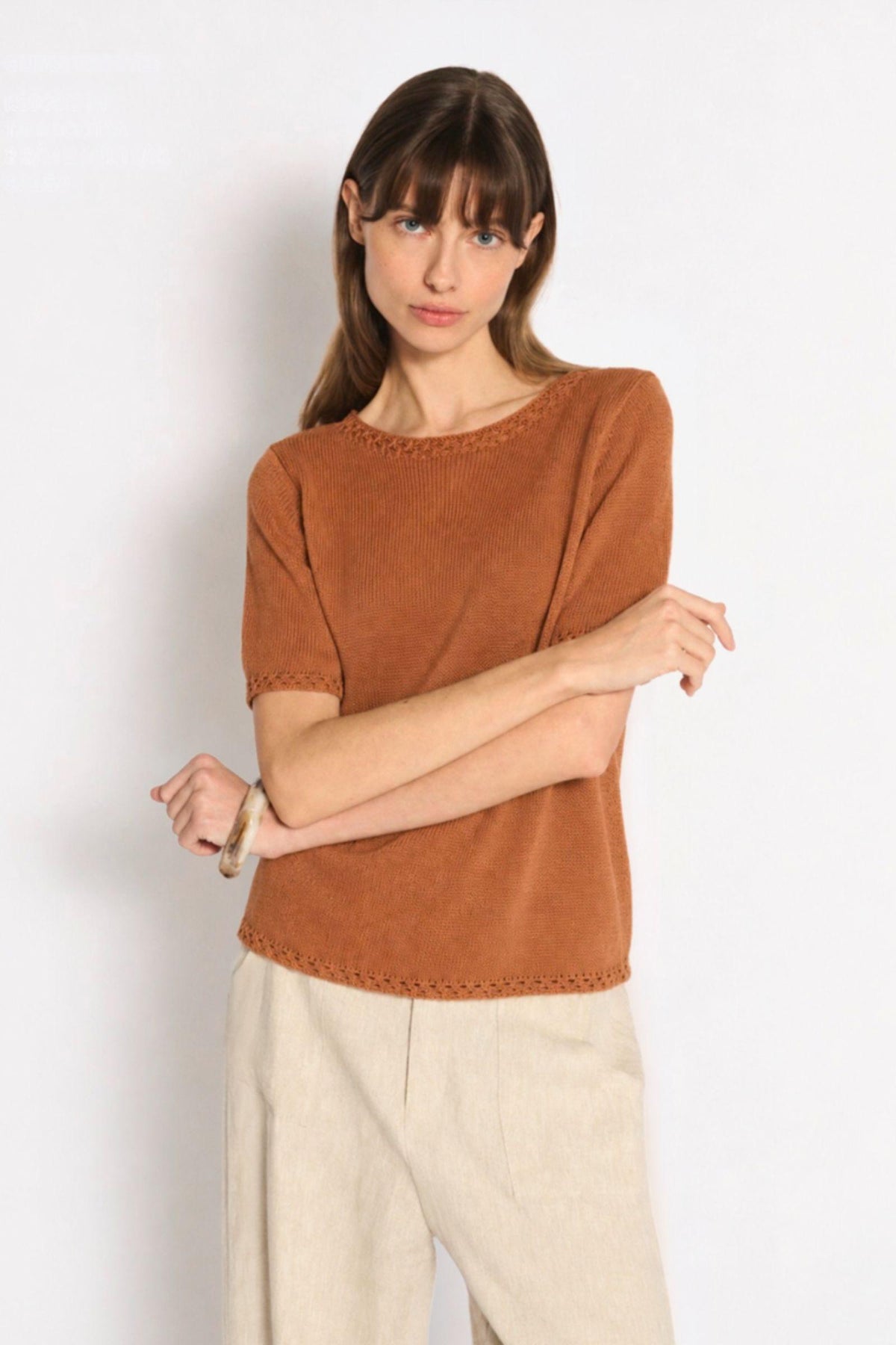 Little Lies Olivia Trim Tee in Terracotta front view with arms crossed, worn with natural pants