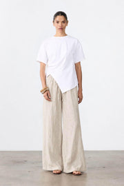 Ruched Jersey Tee by Little Lies — full-length view of a white short-sleeve jersey tee with ruched side detailing and a draped hem, styled with cream wide-leg trousers, available in Australia at Kat and Ko Clothing.
