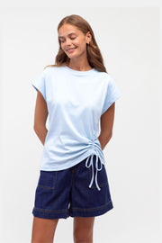 Mandy Drawstring Tee by Label of Love — front view of the baby blue tee with an adjustable side tie, styled with navy shorts, available in Australia at Kat and Ko Clothing