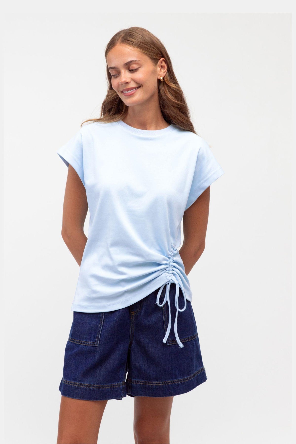 Mandy Drawstring Tee by Label of Love — front view of the baby blue tee with an adjustable side tie, styled with navy shorts, available in Australia at Kat and Ko Clothing