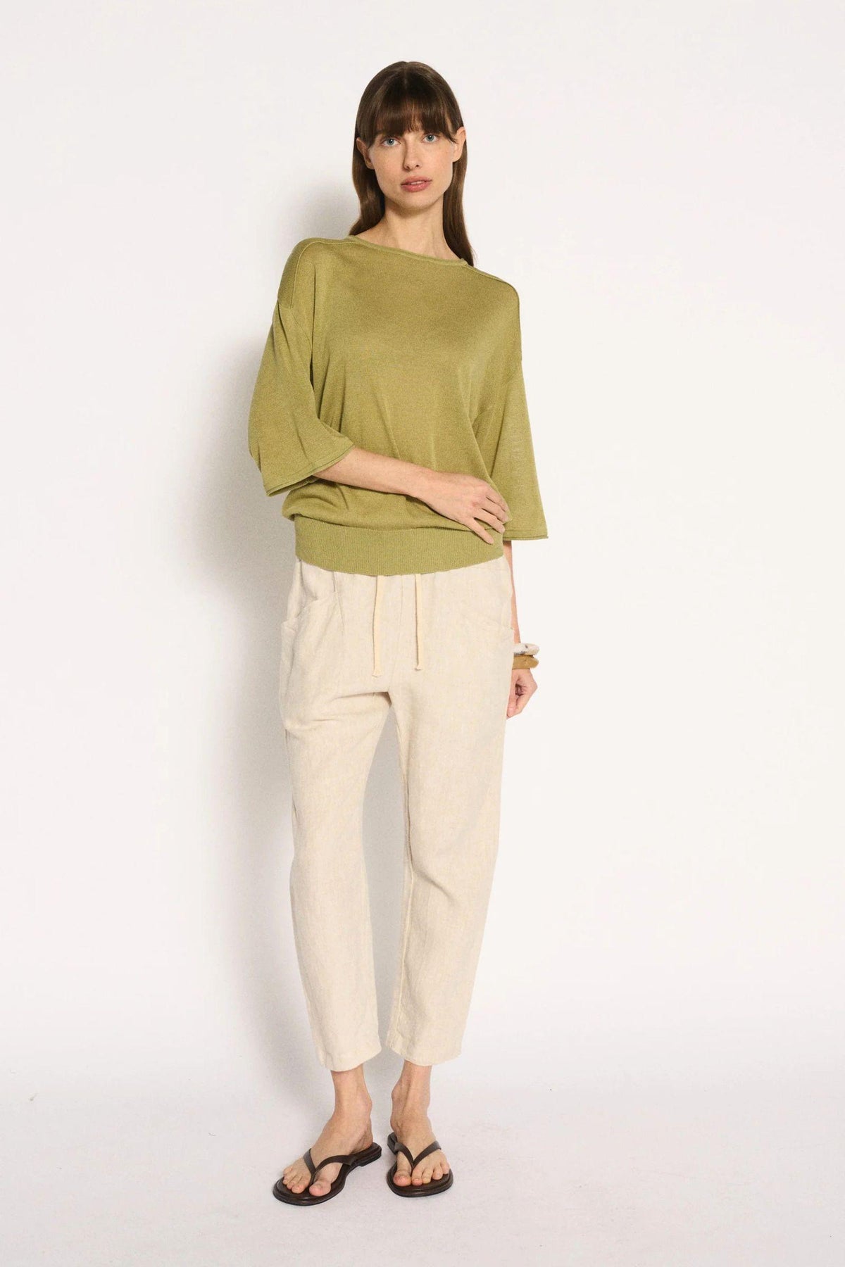 Little Lies Cassie Knit Top in Sage full-length view of the relaxed fit, styled with cream pants and black sandals
