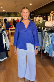 Little Lies Boyfriend Shirt in Cobalt full-length front view, half-tucked into white cropped linen pants