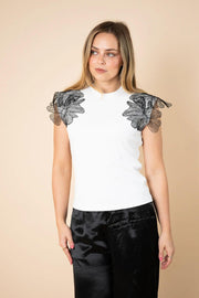 Fria The Label Lace Wing Tee in White with black lace flower sleeves, front view with black satin pants