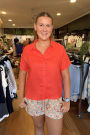Little Lies Bronte Shirt in Vivid Orange front view with collar and short sleeves, worn with the Margot Shorts