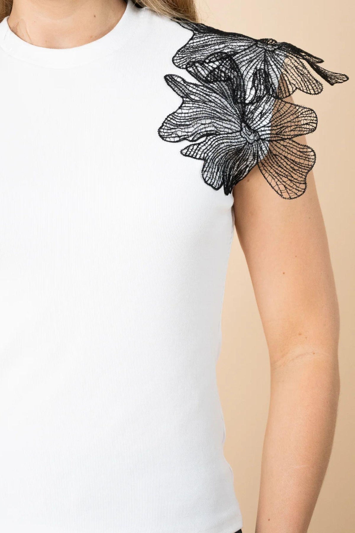 Fria The Label Lace Wing Tee in White, close-up of the black floral lace wing sleeve