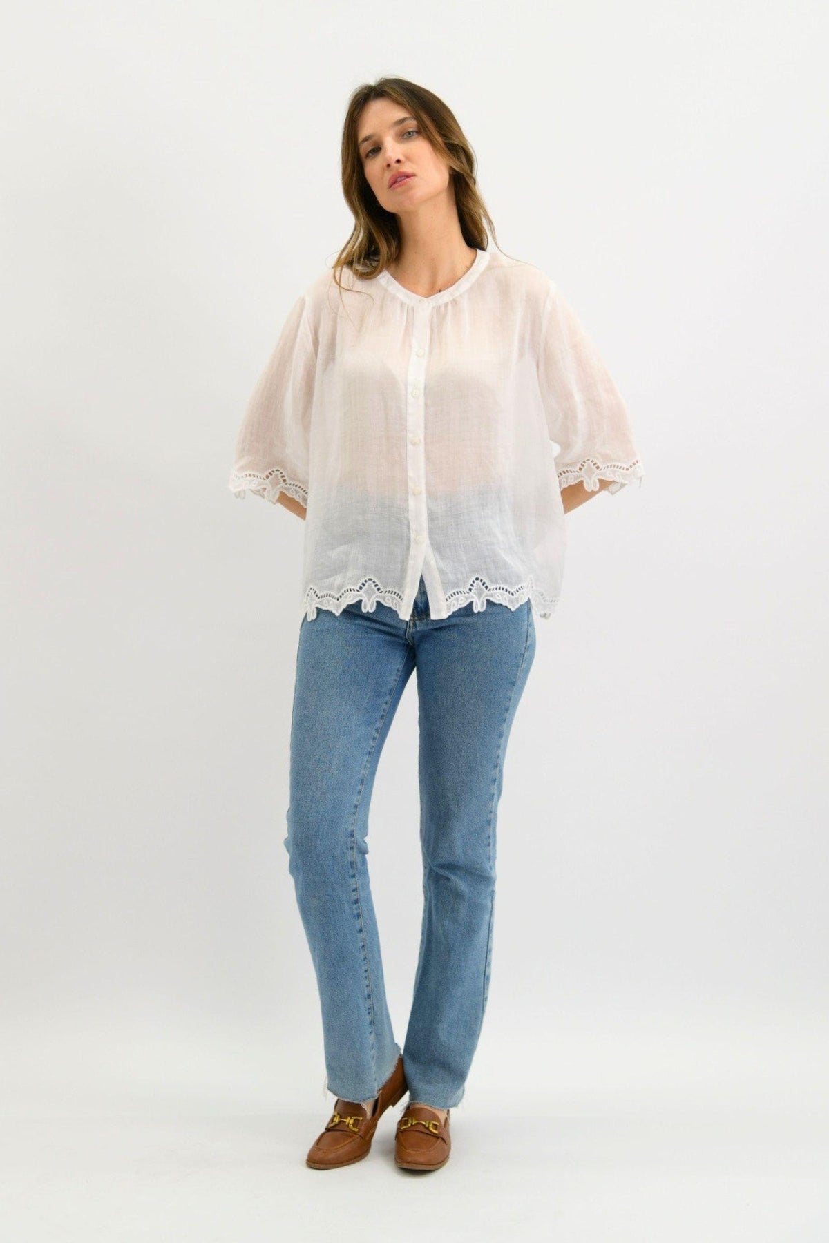 Worthier Tansy Linen Top in White front view with lace-trim sleeves and hem, worn with light blue jeans