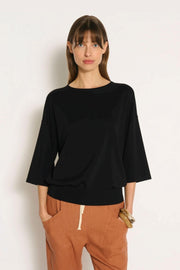 Little Lies Cassie Knit Top in Black front view of the relaxed fit, styled with rust drawstring pants