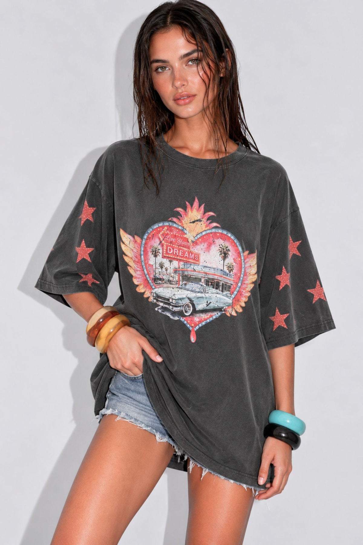 Live Your Dreams Tee by Coco Cartel — front view of the oversized charcoal graphic tee with pink sleeve motifs, styled with denim shorts, available in Australia at Kat and Ko Clothing