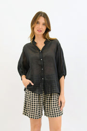 Aurora Linen Top - Black by Worthier — front view of the black button-up top with mid-length sleeves, styled with checked shorts in Australia at Kat and Ko Clothing.