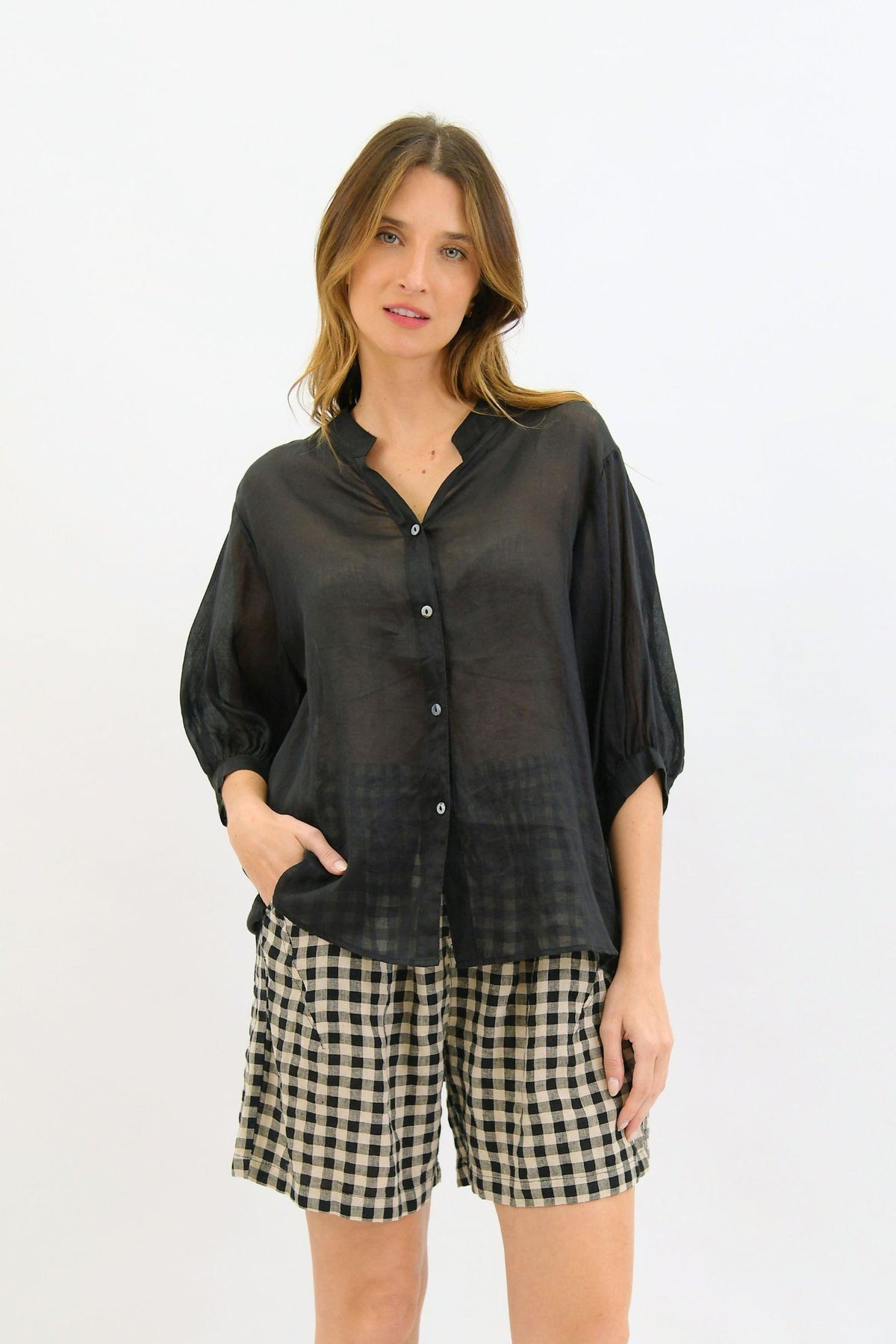 Aurora Linen Top - Black by Worthier — front view of the black button-up top with mid-length sleeves, styled with checked shorts in Australia at Kat and Ko Clothing.