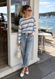 Hailey Drawstring Top in Blue Stripe by Little Lies — front view of blue and white striped cotton drawstring top styled with light wash jeans, white Mary Jane flats and cream bag at a waterfront café, available in Australia at Kat and Ko Clothing
