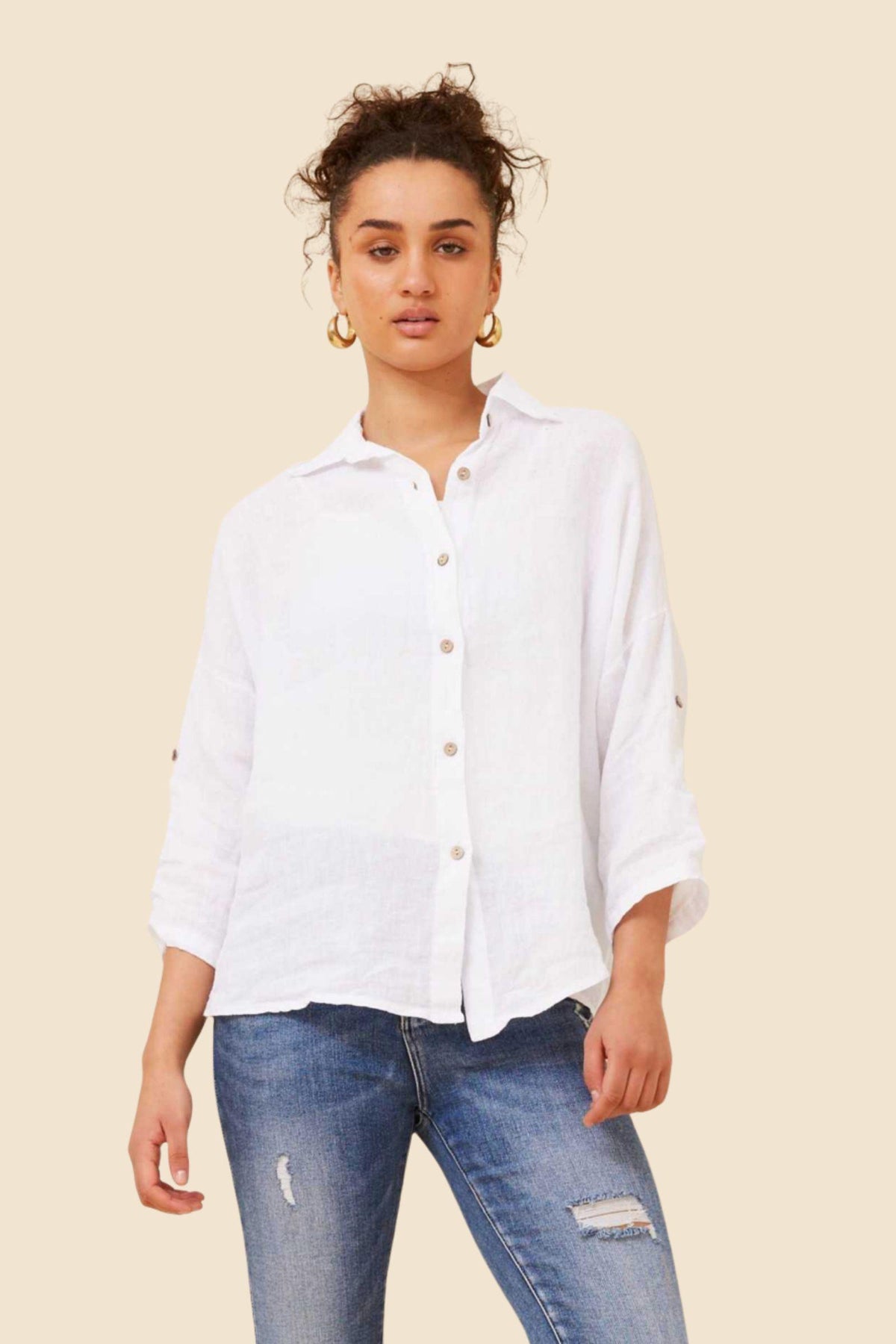 Pina Linen Shirt in White by Bottega Moda — front view of relaxed white linen button-up with roll-tab sleeves, styled with distressed denim jeans, available in Australia at Kat and Ko Clothing