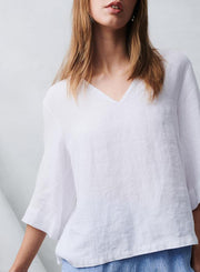 Woman wearing a white blouse against a light gray background